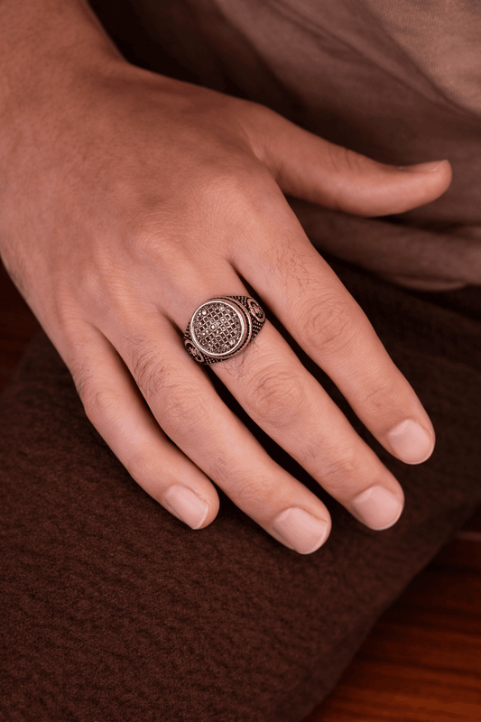 A man wearing a Turkish-inspired oval ring featuring a cubical zircon micro-pave center and antique silver stainless steel finish