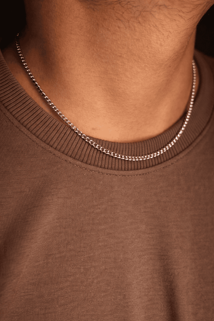 Men stainless steel curb chain necklace in Pakistan, polished silver curb link chain worn with brown shirt, durable waterproof everyday men jewelry