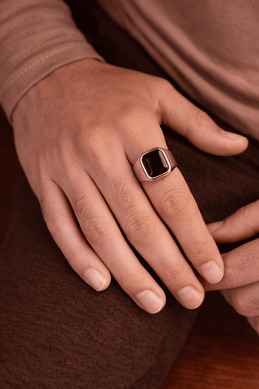 A man wearing a sleek, modern black agate signet ring with a polished silver stainless steel band, perfect for office or formal wear.