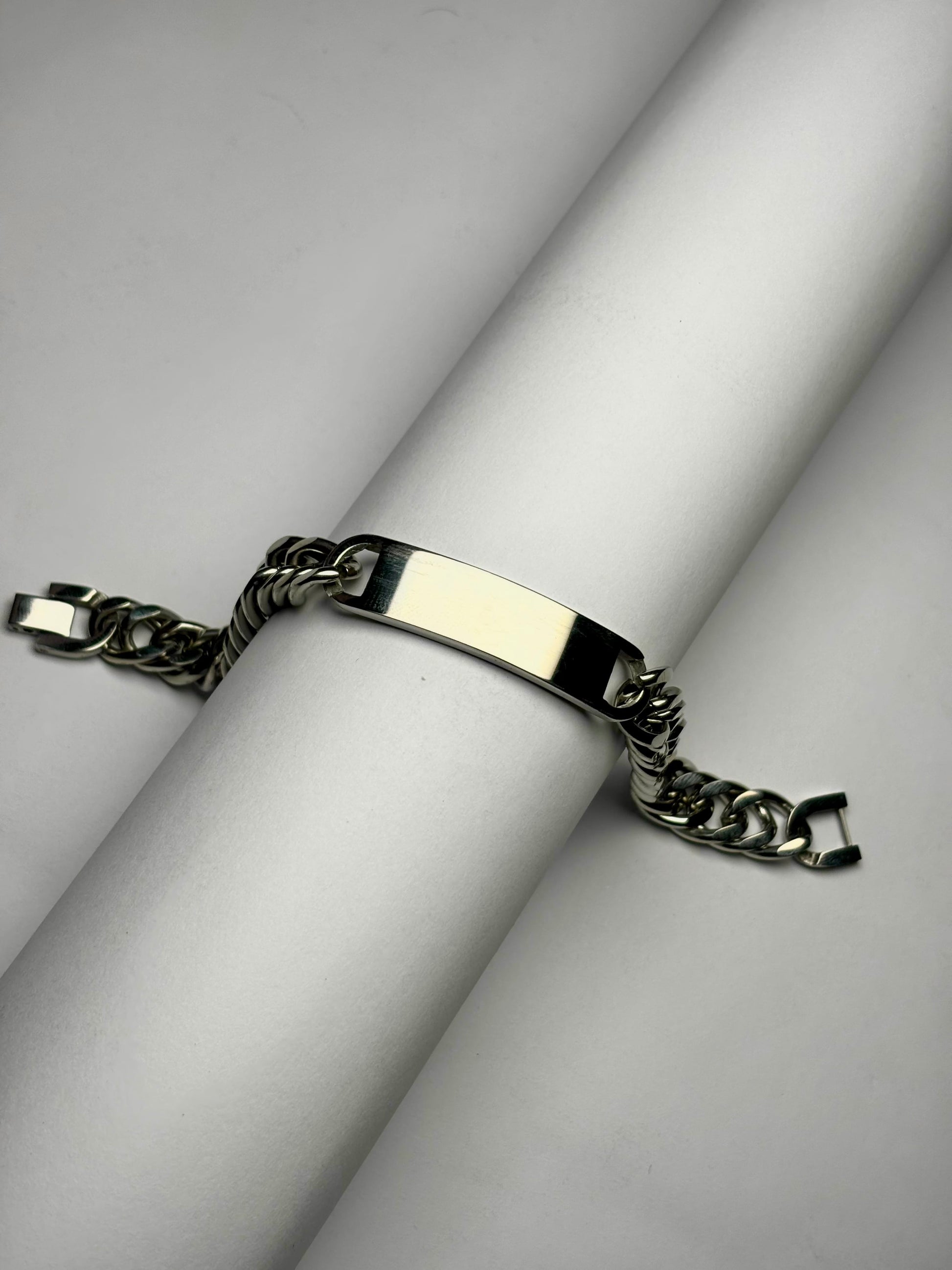 Close-up of polished Cuban link bracelet with engraving plate, men’s stainless steel personalized bracelet detail shot