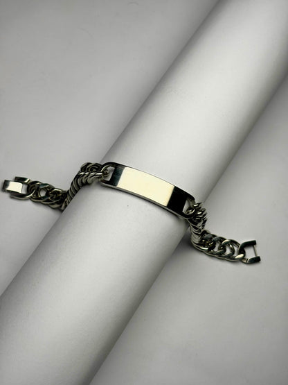 Close-up of polished Cuban link bracelet with engraving plate, men’s stainless steel personalized bracelet detail shot