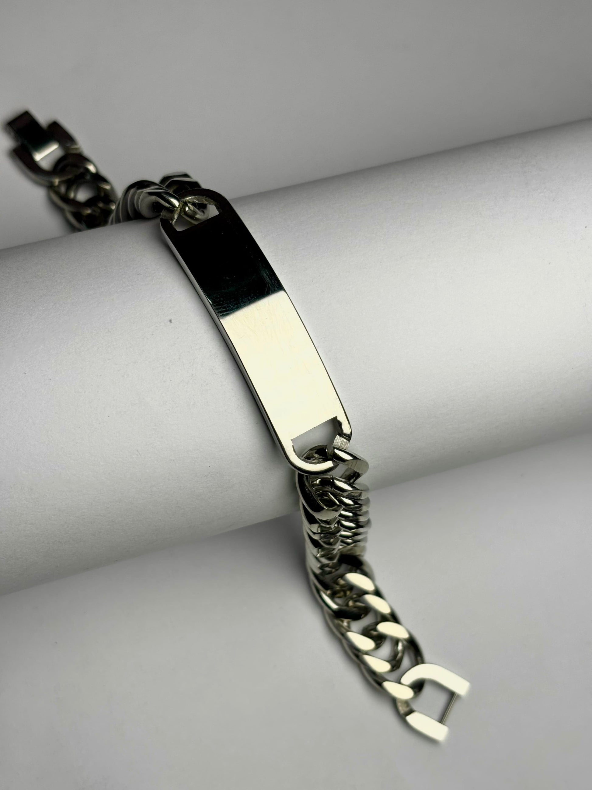 Close-up of polished Cuban link bracelet with engraving plate, men’s stainless steel personalized bracelet detail shot