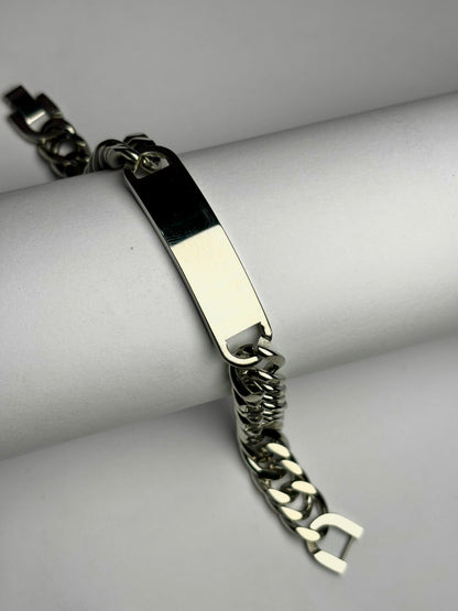Close-up of polished Cuban link bracelet with engraving plate, men’s stainless steel personalized bracelet detail shot