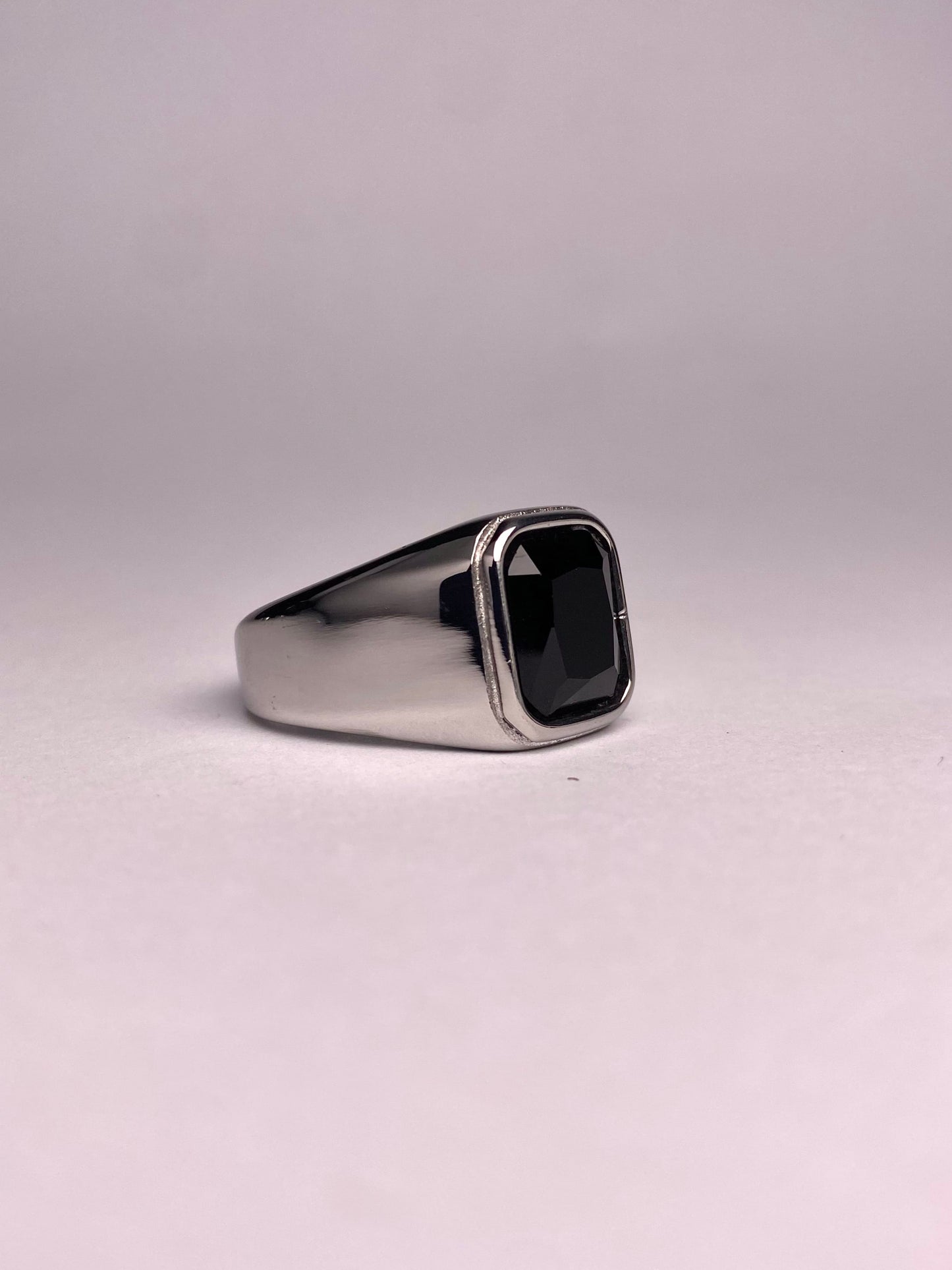 Side perspective of a premium black stone ring showing the mirror-finish stainless steel surface and rectangular agate gemstone.