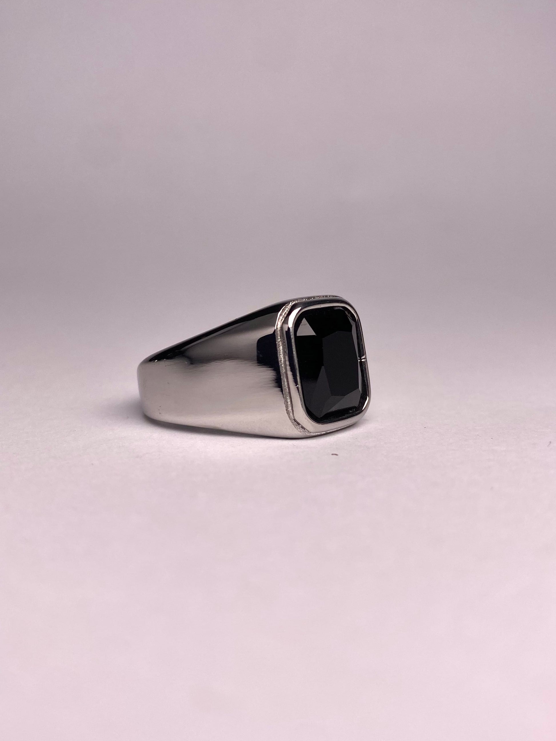 Side perspective of a premium black stone ring showing the mirror-finish stainless steel surface and rectangular agate gemstone.