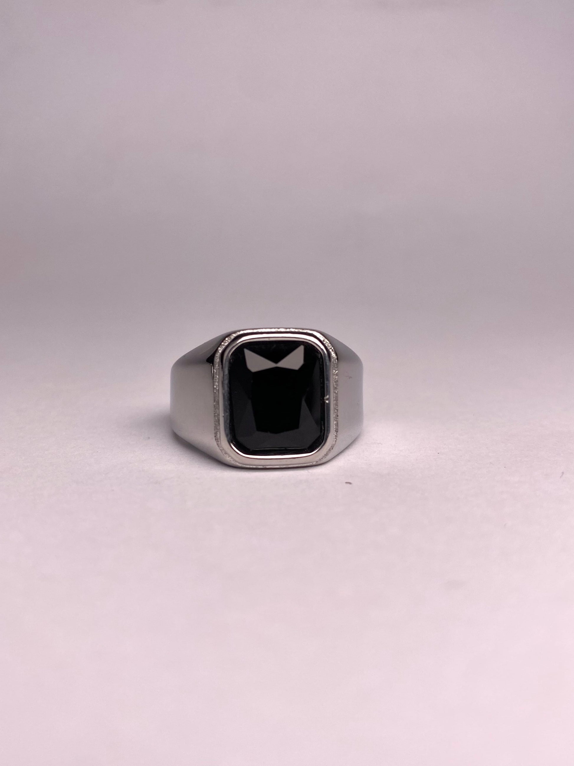 Angled view of a rust-proof stainless steel ring for men featuring a deep black rectangular agate stone.